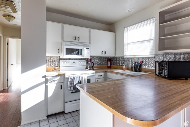 5952 S 2550 W, Roy, UT 84067 - kitchen featuring white cabinetry, a peninsula, backsplash, and white appliances