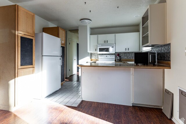 5952 S 2550 W, Roy, UT 84067 - kitchen featuring open shelves, a peninsula, wood finished floors, white appliances, and backsplash