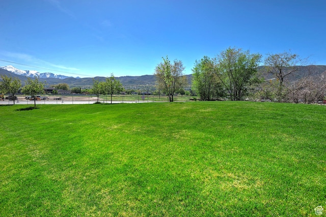 view of yard featuring a mountain view and fence