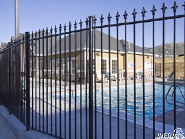 view of gate with a community pool and fence