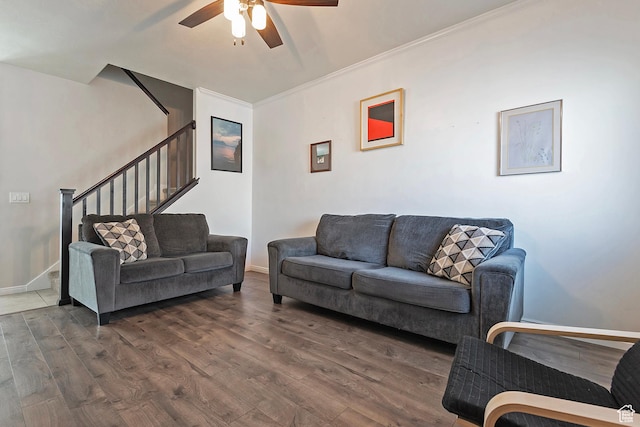 living area featuring baseboards, ceiling fan, wood finished floors, and stairway