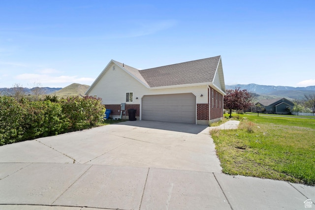 220 N 810 E, Smithfield, UT 84335 - view of home's exterior featuring an attached garage, brick siding, a mountain view, a lawn, and driveway