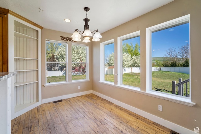 220 N 810 E, Smithfield, UT 84335 - unfurnished dining area featuring an inviting chandelier, baseboards, wood-type flooring, and visible vents