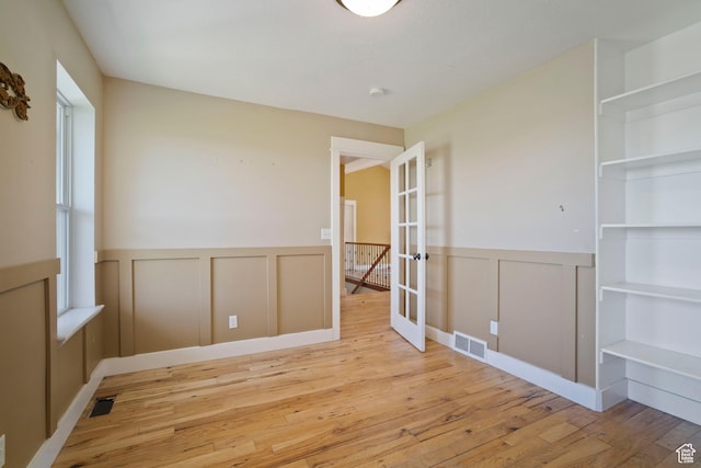 220 N 810 E, Smithfield, UT 84335 - unfurnished room featuring french doors, a decorative wall, visible vents, and hardwood / wood-style flooring