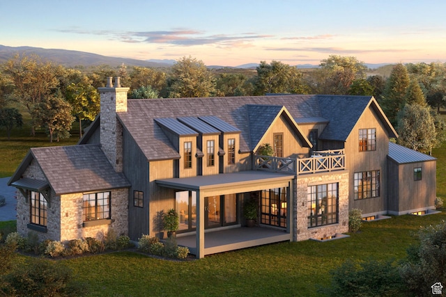 back of property at dusk with a lawn, a patio area, french doors, and a chimney