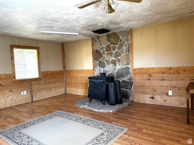 848 N Cooley St W, Grantsville, UT 84029 - unfurnished living room with wooden walls, a wood stove, and a wainscoted wall