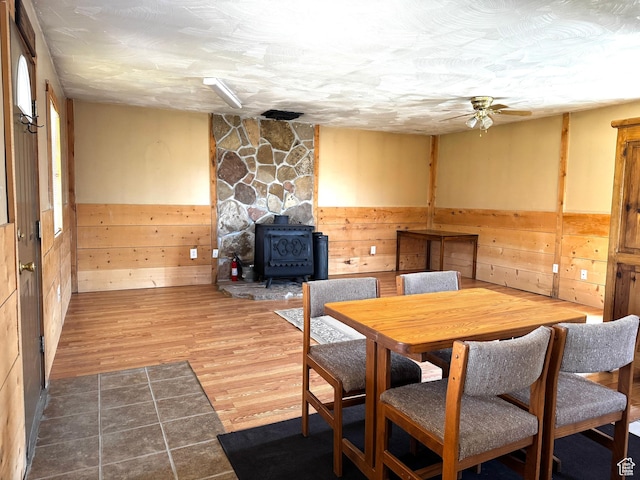 848 N Cooley St W, Grantsville, UT 84029 - dining space featuring a wood stove, wainscoting, a ceiling fan, and wood walls