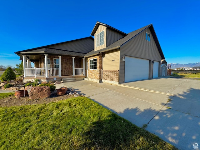 848 N Cooley St W, Grantsville, UT 84029 - view of front of home featuring covered porch, brick siding, a mountain view, concrete driveway, and a shingled roof