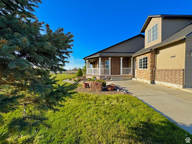 848 N Cooley St W, Grantsville, UT 84029 - exterior space with a porch, a lawn, and brick siding