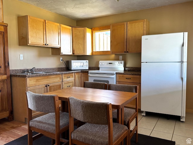 848 N Cooley St W, Grantsville, UT 84029 - kitchen featuring a sink, dark countertops, light tile patterned floors, and white appliances
