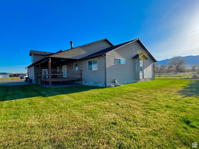 848 N Cooley St W, Grantsville, UT 84029 - rear view of house with a yard, fence, and a mountain view