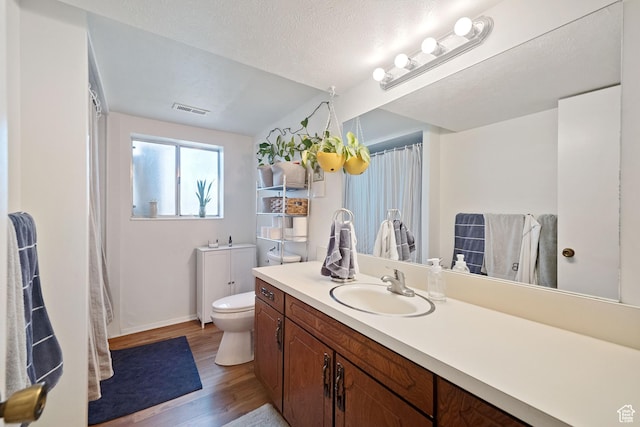 9968 S Blossom Dr, Sandy, UT 84092 - bathroom featuring wood finished floors, vanity, toilet, baseboards, and a shower with shower curtain
