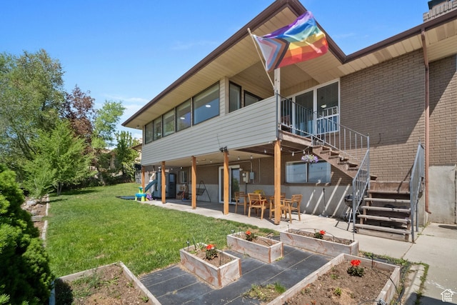 9968 S Blossom Dr, Sandy, UT 84092 - rear view of house featuring a garden, a patio area, stairway, a yard, and brick siding
