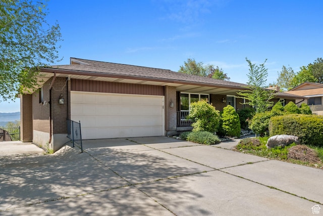 9968 S Blossom Dr, Sandy, UT 84092 - view of front of house featuring an attached garage, driveway, and brick siding