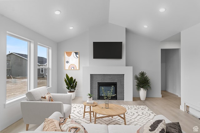 167 N 950 E Unit 33, Tremonton, UT 84337 - living area with baseboards, light wood finished floors, lofted ceiling, a glass covered fireplace, and recessed lighting