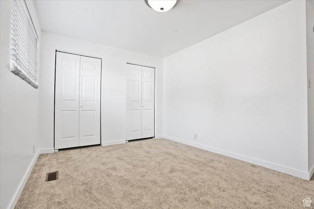 218 E Julie Anna Dr, Sandy, UT 84070 - unfurnished bedroom with baseboards, two closets, carpet flooring, and visible vents
