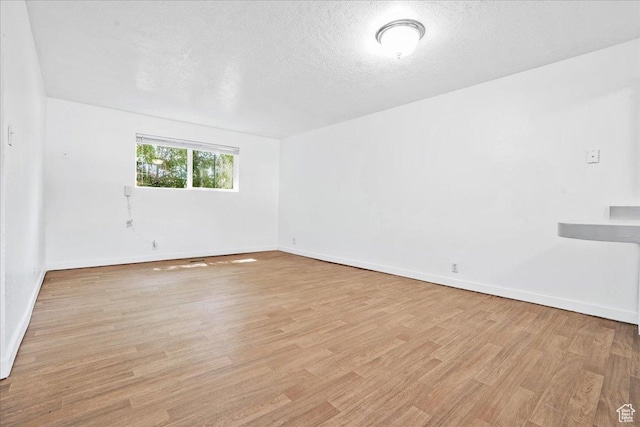 218 E Julie Anna Dr, Sandy, UT 84070 - empty room with a textured ceiling, baseboards, and light wood-type flooring