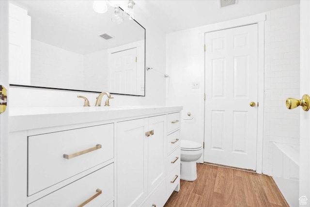 218 E Julie Anna Dr, Sandy, UT 84070 - full bathroom with vanity, a bathing tub, toilet, wood finished floors, and visible vents
