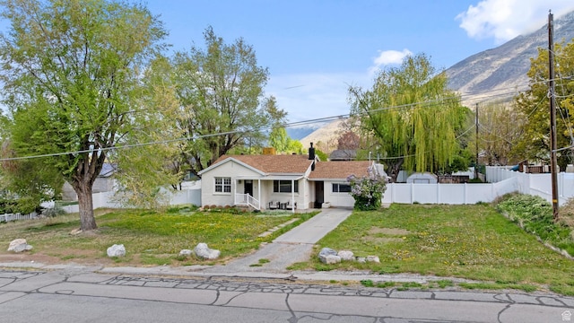 605 E 700 N, Pleasant Grove, UT 84062 - view of front of home with a front lawn, fence, covered porch, stucco siding, and a mountain view
