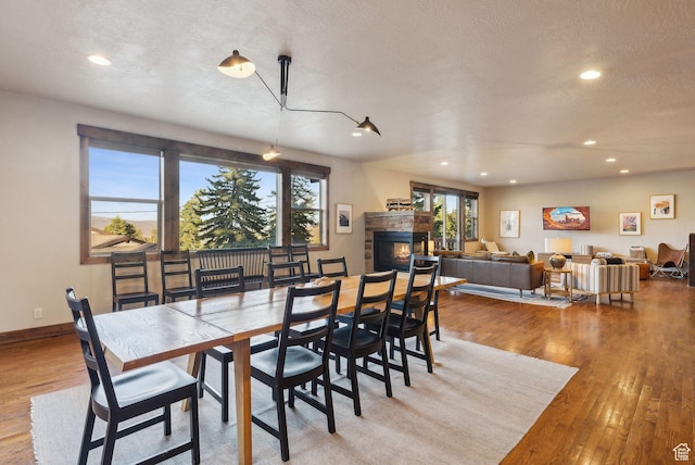 210 Parkview Dr, Summit Park, UT 84098 - dining room featuring recessed lighting, a textured ceiling, a glass covered fireplace, and wood finished floors