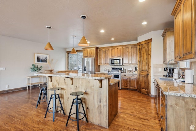 210 Parkview Dr, Summit Park, UT 84098 - kitchen featuring a kitchen breakfast bar, a center island, brown cabinets, dark wood finished floors, and appliances with stainless steel finishes