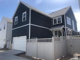 exterior space featuring concrete driveway, an attached garage, and fence