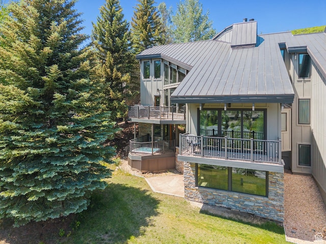 1386 Pinnacle Dr Unit 82, Park City, UT 84060 - rear view of property featuring a standing seam roof, a chimney, a metal roof, a lawn, and stone siding