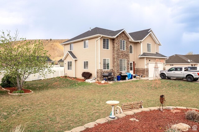 4231 W 650 N, Vernal, UT 84078 - back of house with fence, an attached garage, a yard, and stone siding