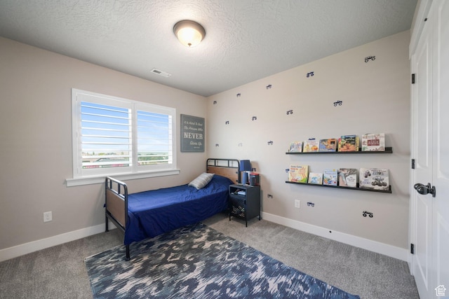 carpeted bedroom featuring baseboards, a textured ceiling, and visible vents