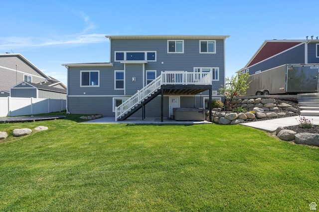 back of house with fence, a patio area, a lawn, a hot tub, and stairway