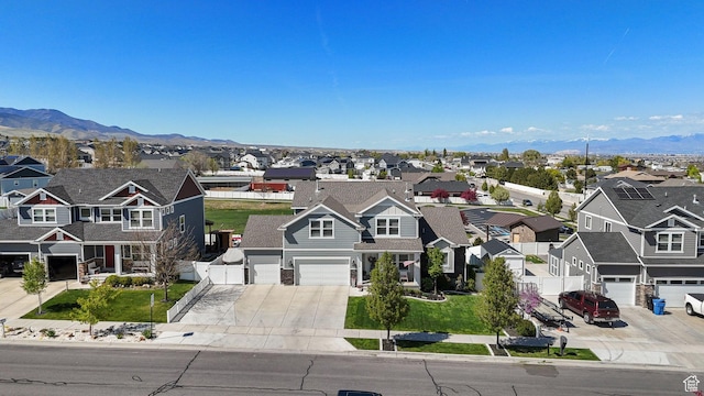 view of front of house with a garage, a mountain view, a residential view, and concrete driveway