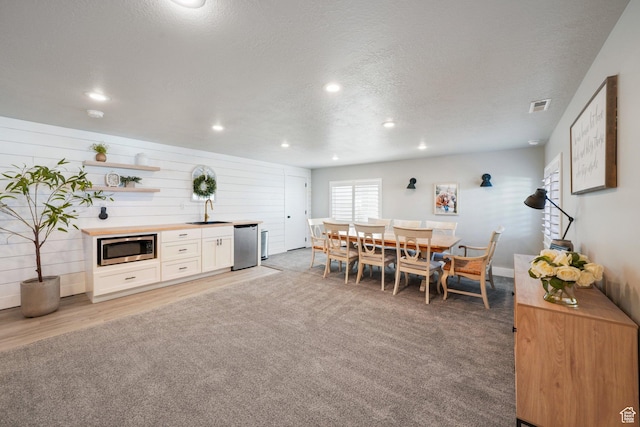 dining room featuring recessed lighting, a textured ceiling, visible vents, and light carpet