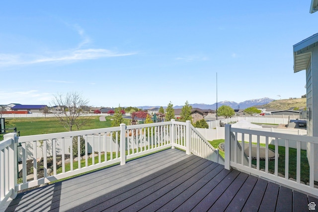 deck with a fenced backyard, a mountain view, and a residential view