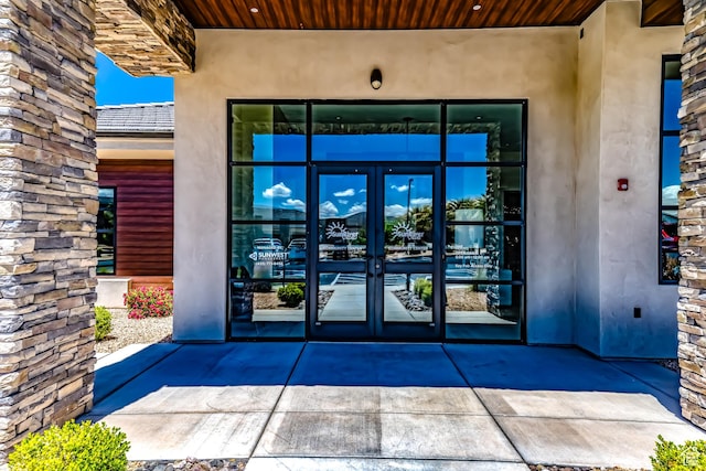 property entrance featuring french doors and stucco siding