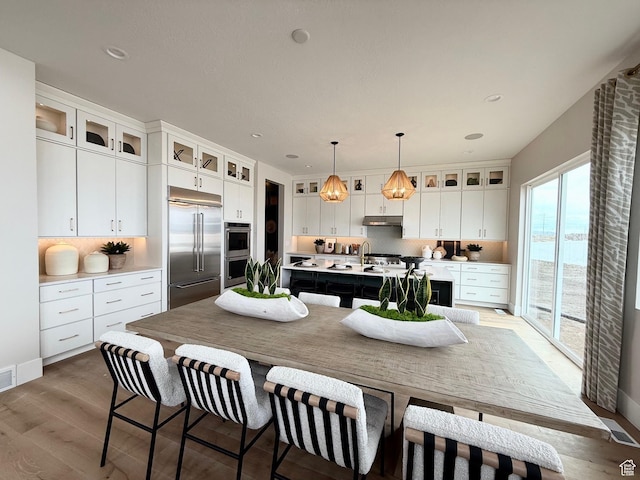 1154 W Gossamer Ln Unit 10, Saratoga Springs, UT 84045 - kitchen featuring light countertops, appliances with stainless steel finishes, backsplash, and an island with sink