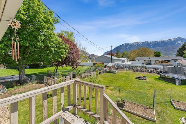 222 N 600th St E, Orem, UT 84097 - view of yard featuring a garden, a trampoline, a mountain view, a fenced backyard, and a fire pit