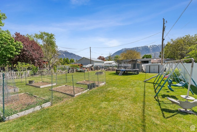 222 N 600th St E, Orem, UT 84097 - view of yard with a trampoline, a storage shed, a vegetable garden, a mountain view, and an outdoor structure
