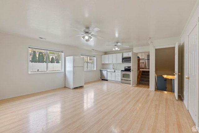 10046 N Sage Rd W, Cedar Hills, UT 84062 - unfurnished living room with a sink, light wood finished floors, stairs, a ceiling fan, and visible vents