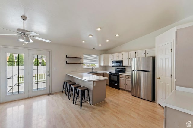 10046 N Sage Rd W, Cedar Hills, UT 84062 - kitchen with a breakfast bar, a sink, light wood-style flooring, a peninsula, and black appliances