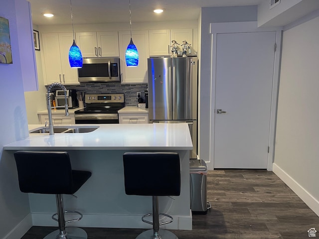 1206 E Waterside Cv Unit 21, Cottonwood Heights, UT 84047 - kitchen featuring appliances with stainless steel finishes, baseboards, a peninsula, a breakfast bar, and white cabinetry