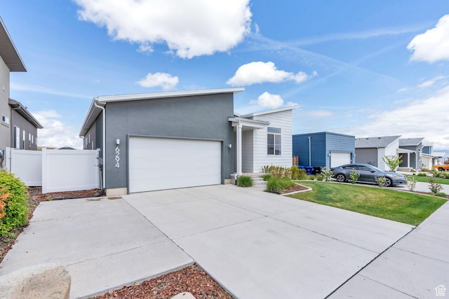 6294 W 7830 S, West Jordan, UT 84081 - view of front of house with fence, an attached garage, driveway, and stucco siding