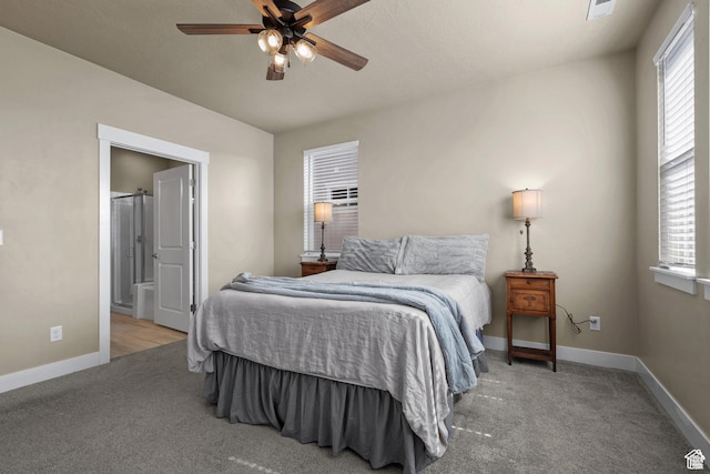 bedroom with carpet floors, baseboards, ensuite bathroom, and a ceiling fan