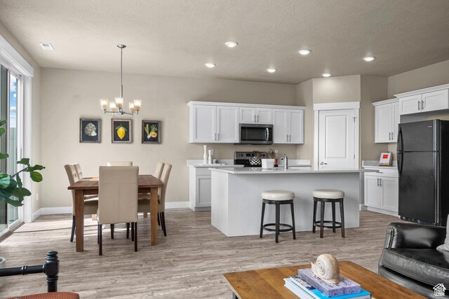 interior space with light countertops, appliances with stainless steel finishes, a breakfast bar area, and white cabinets