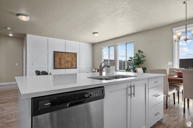 kitchen featuring a sink, dishwasher, a textured ceiling, a chandelier, and wood finished floors