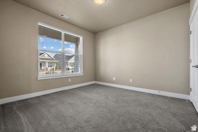 carpeted spare room with visible vents and baseboards
