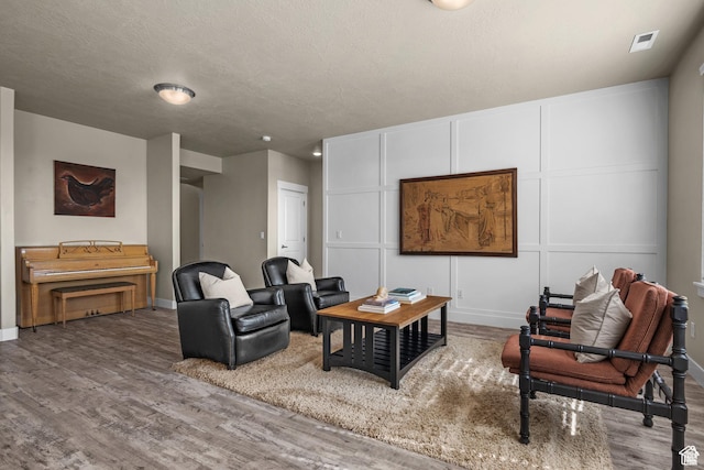 living room featuring baseboards, wood finished floors, and visible vents