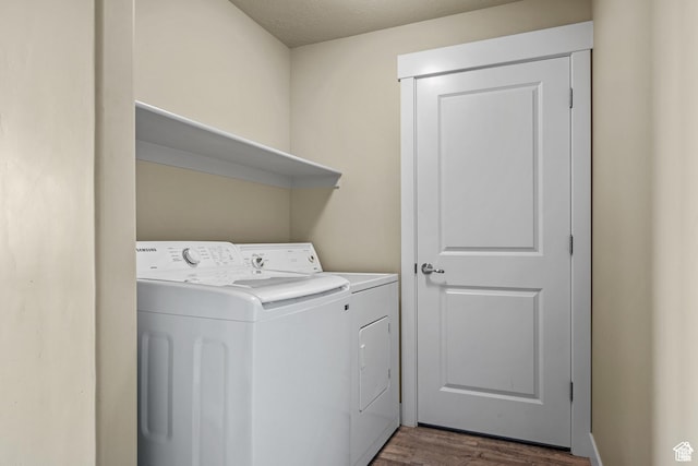 washroom featuring laundry area, dark wood finished floors, and washer and dryer