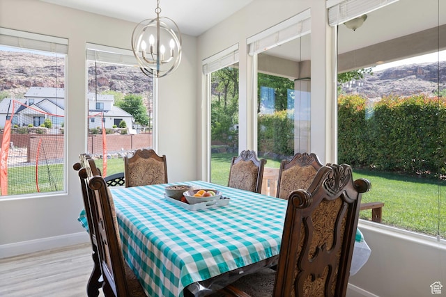 dining room featuring baseboards, wood finished floors, and a notable chandelier