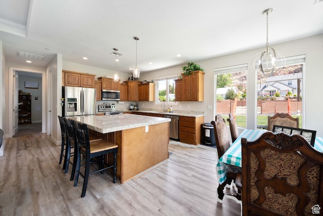 kitchen featuring light wood-style floors, appliances with stainless steel finishes, a kitchen island, and visible vents