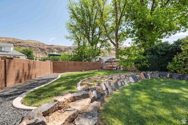 view of yard featuring a mountain view and fence